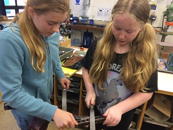 Cerys and Jade cleaning up the support brace for the roll bar for the new car 350 pixels
